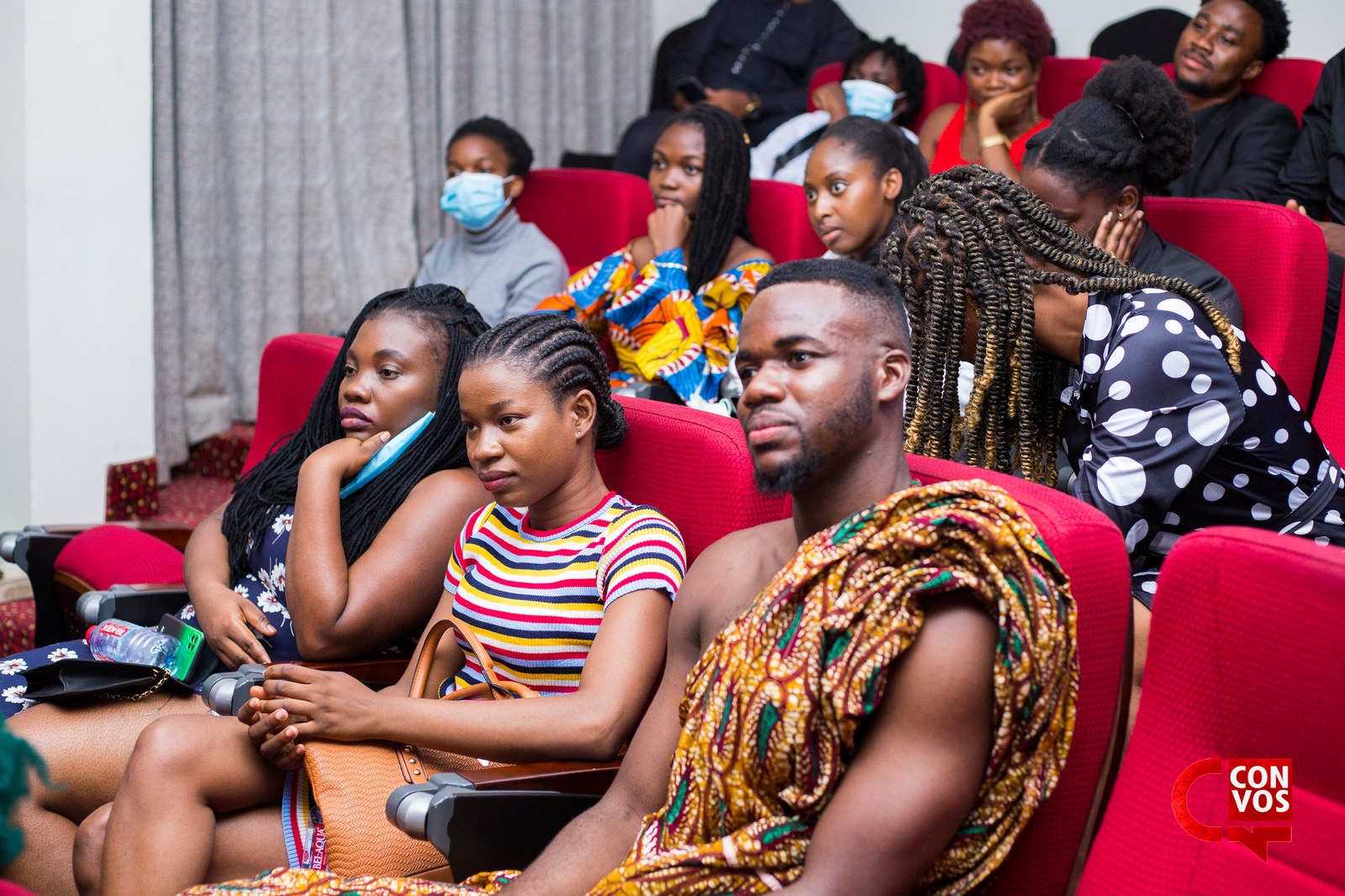 Audience in Ghanaian kente captivated by spoken word