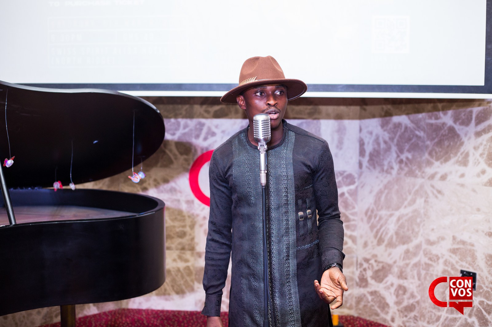 Poet in fedora performing passionately with hand gestures